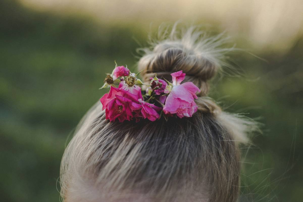 Infographic comparing 4 types of hair buns: low chignon, high messy bun, twisted rope bun, and sock bun—with icons showing time required, hold strength, and best hair types