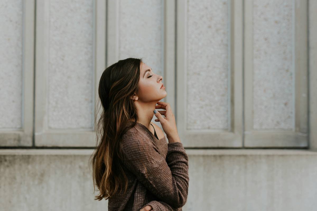 fast updo hairstyle ideas featuring a woman with a neat, low hair bun using a satin scrunchie